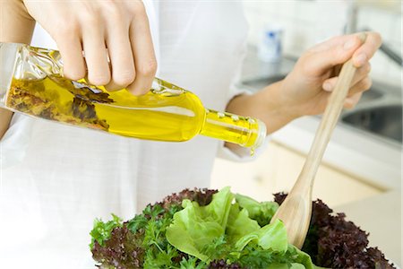 Woman pouring olive oil dressing over salad, cropped view Foto de stock - Sin royalties Premium, Código: 695-05779324
