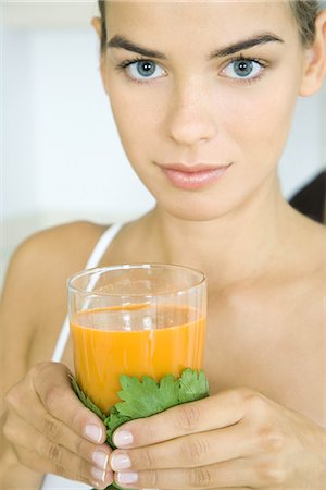 Jeune femme tenant un verre de jus de légumes, en regardant la caméra, tête et épaules Photographie de stock - Premium Libres de Droits, Code: 695-05779320