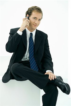 Businessman using cell phone, smiling at camera Stock Photo - Premium Royalty-Free, Code: 695-05779333