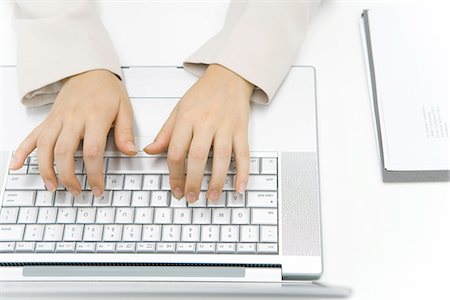 Person typing on laptop computer, cropped view of hands, overhead view Fotografie stock - Premium Royalty-Free, Codice: 695-05779356