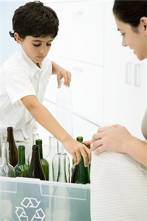 sorting recycling - Young woman and boy sorting glass bottles into recycling bin, cropped view Stock Photo - Premium Royalty-Free, Code: 695-05779385