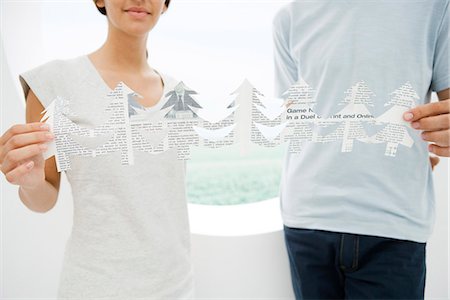 simsearch:6118-09079638,k - Young couple holding ends of cut out paper trees, cropped view Foto de stock - Royalty Free Premium, Número: 695-05779392