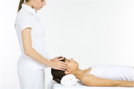 Woman lying on her back receiving head massage, eyes closed Stock Photo - Premium Royalty-Free, Code: 695-05779442