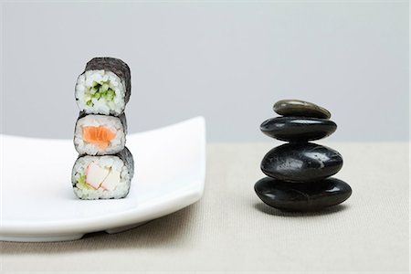 simsearch:695-05773072,k - Stack of three pieces of maki sushi placed alongside stack of shiny black pebbles Foto de stock - Sin royalties Premium, Código: 695-05779480