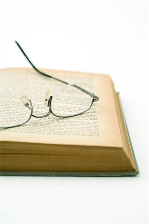 simsearch:695-05779533,k - Pair of glasses resting on yellowed page of open book Foto de stock - Sin royalties Premium, Código: 695-05779518