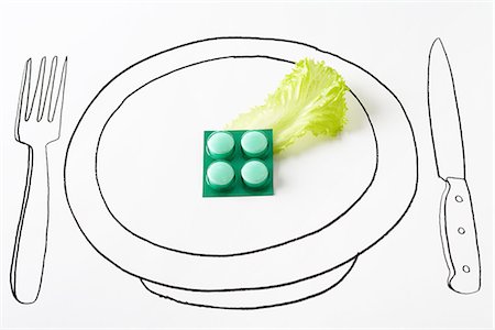 Blister pack of pills and single piece of lettuce on plate Stock Photo - Premium Royalty-Free, Code: 695-05779511