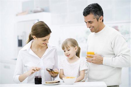 Fille de parents et de jeunes préparant le petit déjeuner dans la cuisine Photographie de stock - Premium Libres de Droits, Code: 695-05779513