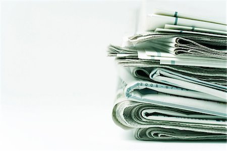 paper stack on white background - Stack of newspapers, close-up Stock Photo - Premium Royalty-Free, Code: 695-05779521