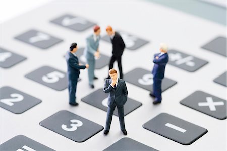 small man - Miniature businessmen standing on calculator Stock Photo - Premium Royalty-Free, Code: 695-05779553