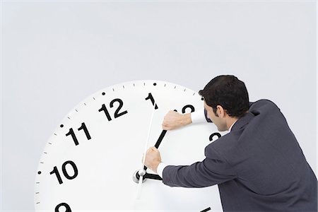 Businessman pushing back hands of clock Stock Photo - Premium Royalty-Free, Code: 695-05779575