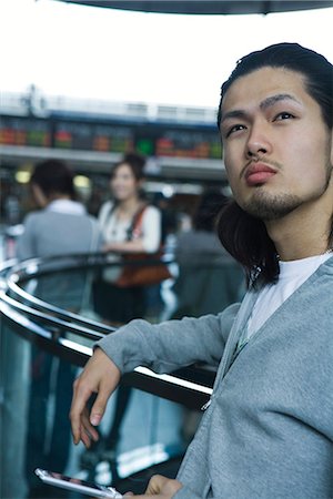 simsearch:6113-07790854,k - Young man leaning against railing, holding cell phone Foto de stock - Royalty Free Premium, Número: 695-05779629
