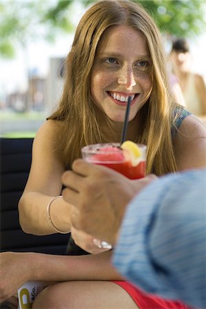 Young woman taking cocktail from friend Stock Photo - Premium Royalty-Free, Code: 695-05779658