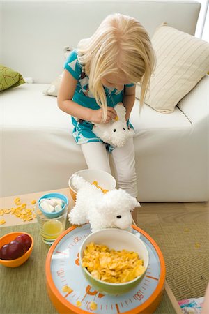 Little girl feeding cereal to stuffed toy Stock Photo - Premium Royalty-Free, Code: 695-05779682