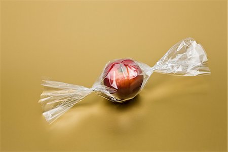 Food concept, fresh apple inside cellophane candy wrapper Stock Photo - Premium Royalty-Free, Code: 695-05779936