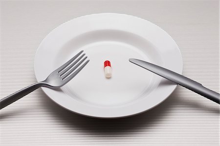 fork and knife on red - Food concept, single pill on plate Foto de stock - Sin royalties Premium, Código: 695-05779937