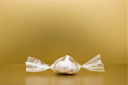 Food concept, head of garlic inside of cellophane candy wrapper Stock Photo - Premium Royalty-Free, Code: 695-05779942