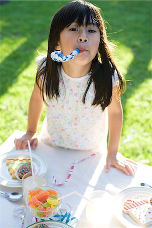 Girl at party enthusiastically blowing party horn blower Stock Photo - Premium Royalty-Free, Code: 695-05779988