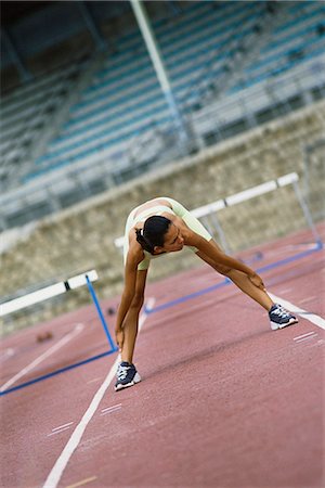 simsearch:614-02763069,k - Woman doing stretches on running track Foto de stock - Royalty Free Premium, Número: 695-05770064