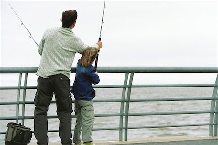 father, son, fishing - Father and son fishing from pier, father helping son with his fishing rod Stock Photo - Premium Royalty-Free, Code: 695-05770101