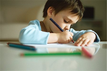 Little boy concentrating on drawing Stock Photo - Premium Royalty-Free, Code: 695-05770150