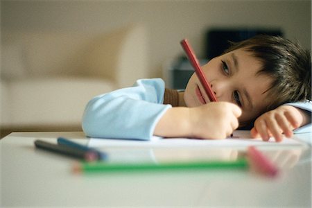 Little boy pausing while drawing, resting head on arm Stock Photo - Premium Royalty-Free, Code: 695-05770151