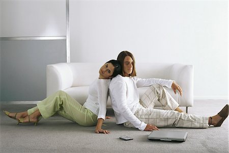 Couple sitting back to back on floor Stock Photo - Premium Royalty-Free, Code: 695-05770366