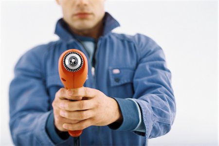 Man pointing drill at camera, cropped Fotografie stock - Premium Royalty-Free, Codice: 695-05770391