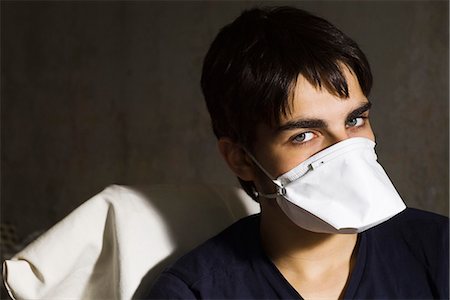 Teenage boy wearing flu mask, looking at camera Stock Photo - Premium Royalty-Free, Code: 695-05770447
