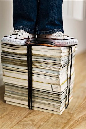 Personne debout sur le dessus de lié la pile de livres et de magazines Photographie de stock - Premium Libres de Droits, Code: 695-05770474