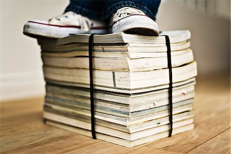 Person standing on top of bound stack of paper catalogs and magazines Foto de stock - Sin royalties Premium, Código: 695-05770472
