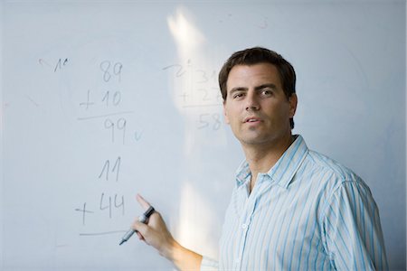 Math teacher pointing to equation on whiteboard Foto de stock - Sin royalties Premium, Código: 695-05770492