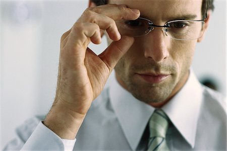 Young businessman adjusting glasses, portrait Stock Photo - Premium Royalty-Free, Code: 695-05770606