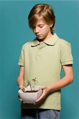 potted plant - Boy holding wilted potted plant Stock Photo - Premium Royalty-Free, Code: 695-05770683