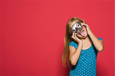 Girl wearing mask, sticking tongue out at camera, portrait Stock Photo - Premium Royalty-Free, Code: 695-05770755