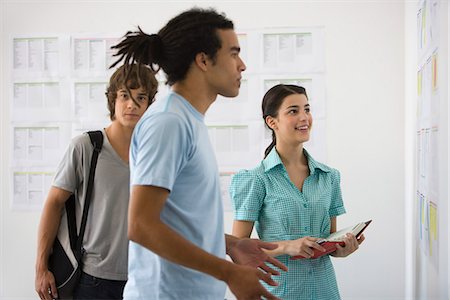 résultat - Étudiant masculin regardant fixement avec incrédulité à résultats affichés sur le babillard, les amis, je regarde au fond Photographie de stock - Premium Libres de Droits, Code: 695-05770787