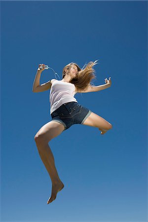 female silhouette jumping - Young woman dancing, jumping outdoors Stock Photo - Premium Royalty-Free, Code: 695-05770845