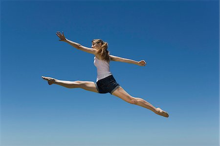 female silhouette jumping - Young woman leaping, midair Stock Photo - Premium Royalty-Free, Code: 695-05770851