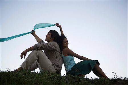 Young couple sitting in grass back to back Stock Photo - Premium Royalty-Free, Code: 695-05770876