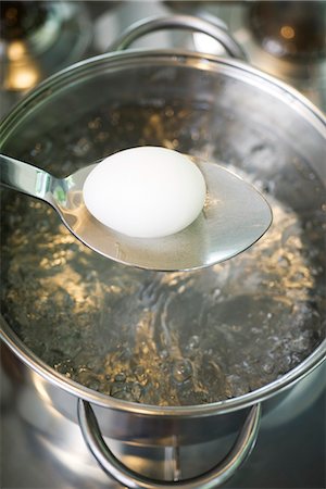 Placing egg in boiling water Foto de stock - Sin royalties Premium, Código: 695-05770932