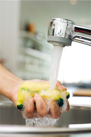 pinching hand - Person rinsing sponge under kitchen faucet Stock Photo - Premium Royalty-Free, Code: 695-05770960