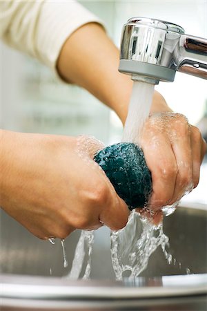 pincement - Personne rincer l'éponge sous le robinet de cuisine Photographie de stock - Premium Libres de Droits, Code: 695-05770961