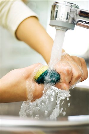 empregada doméstica - Person rinsing sponge under kitchen faucet Foto de stock - Royalty Free Premium, Número: 695-05770962