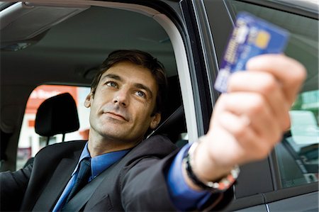 servicio completo - Customer in drive-thru handing credit card to check-out window clerk Foto de stock - Sin royalties Premium, Código: 695-05771068