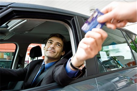 servicio completo - Customer in drive-thru handing credit card to check-out window clerk Foto de stock - Sin royalties Premium, Código: 695-05771069