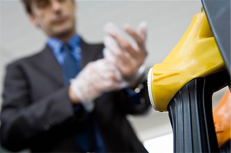 pompe à essence - Mettant de mettre des gants jetables se préparent à faire le plein de véhicules de l'homme Photographie de stock - Premium Libres de Droits, Code: 695-05771063