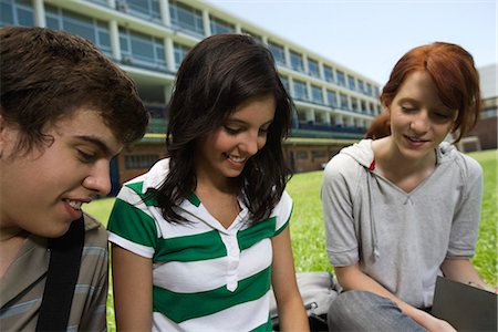 female friends sitting on ground - Teenage friends hanging out, sitting together outdoors on school lawn Stock Photo - Premium Royalty-Free, Code: 695-05771146