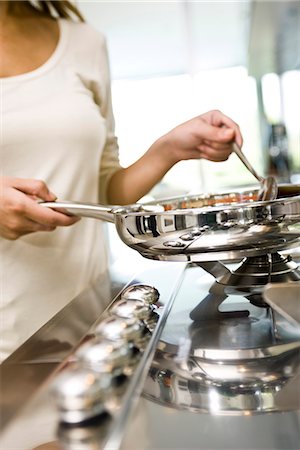 picture of people cooking in frying pan - Cooking on gas stove Stock Photo - Premium Royalty-Free, Code: 695-05771177