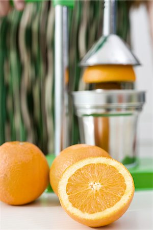 spremiagrumi a mano - Using press to squeeze fresh orange juice Fotografie stock - Premium Royalty-Free, Codice: 695-05771191