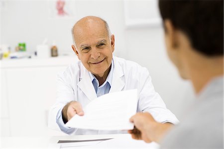 friendly - Doctor handing document to patient Stock Photo - Premium Royalty-Free, Code: 695-05771235