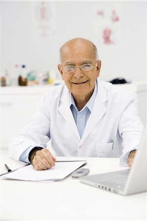 senior man document - Doctor at desk completing paperwork Stock Photo - Premium Royalty-Free, Code: 695-05771232